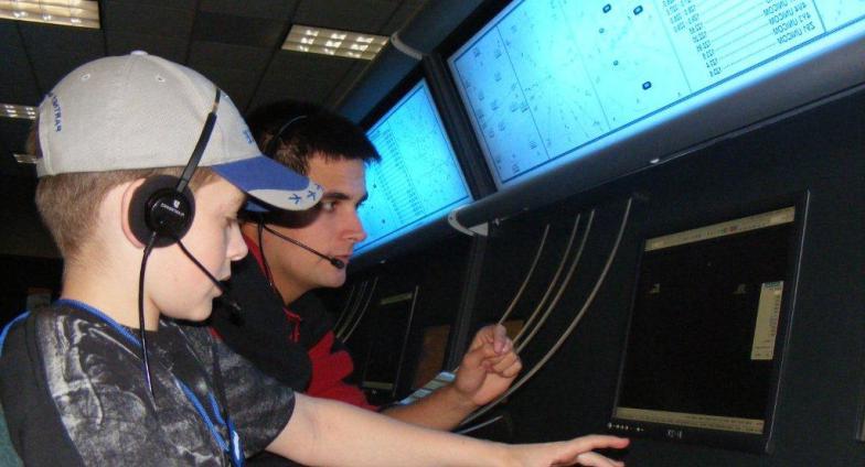 child at computer doing flight simulation with instructor